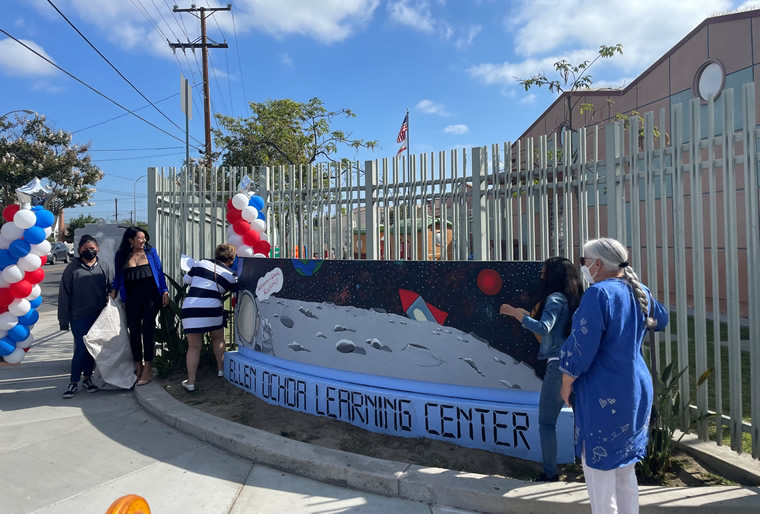 Volunteers in front of the new Ellen Ochoa Learning Center sign