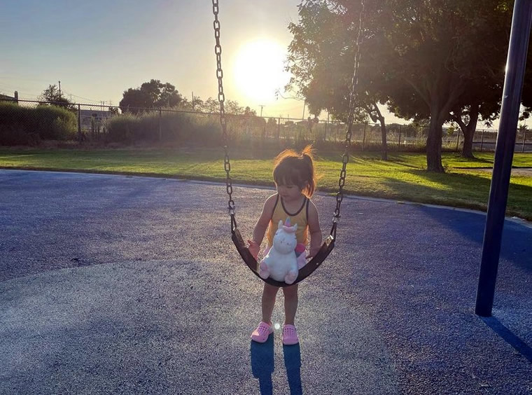 Speaker Rendon's daughter places unicorn toy on swing in playground