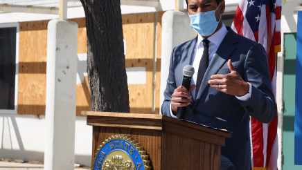 Assemblymember Rivas addressing crowd from behind podium