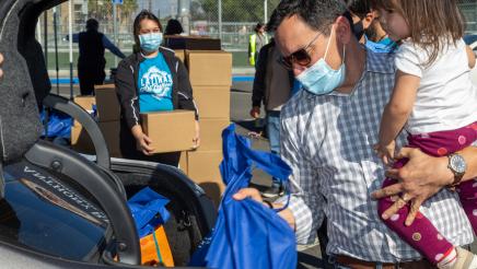 Speaker Rendon, with daughter, placing food bag into trunk