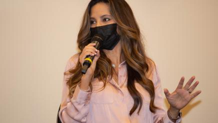 Author Argelia Atilano holding microphone, speaking