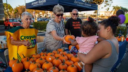 Constituent volunteers at pumpkin giveaway table