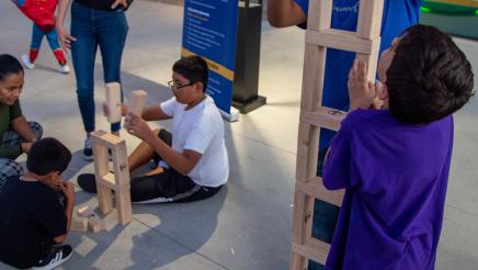 Kids building tall structure with wooden blocks