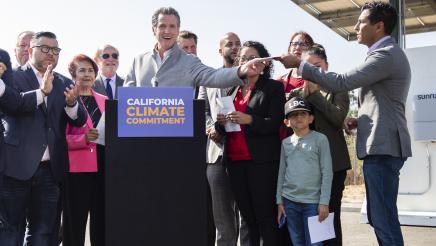 Governor Newsom hands signed legislation to Assemblymember Robert Rivas.
