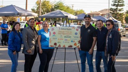 Speaker Rendon and partner representatives, with large sign with logos at center