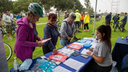 Staffer at Speaker Rendon's services booth distributing informational brochures to constituents